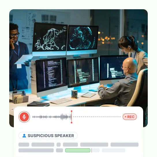 Analysts at a wall of monitors in an operations room, with a live recording running beneath it and its speaker flagged as suspicious